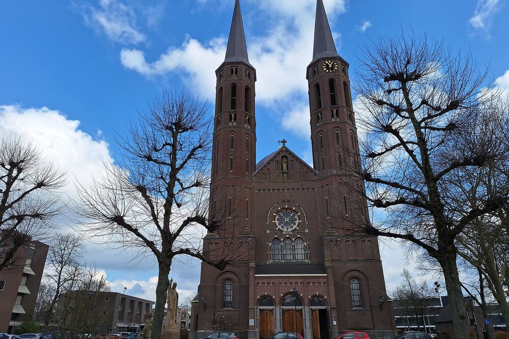De twee torens van de Sint-Petruskerk in Uden onder een blauwe lucht